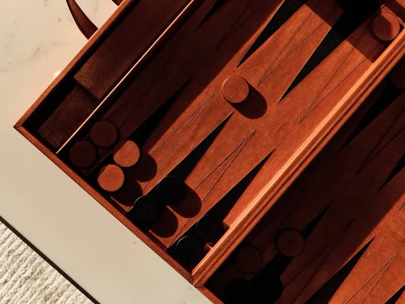 A leather backgammon set on a marble table